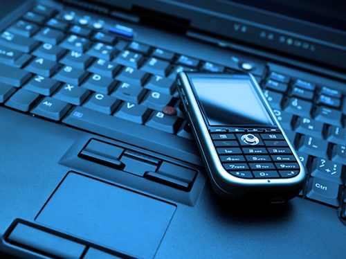 تطبيق جديد يحول اللاب توب إلى هاتف محمول 1 Connect. Laptop and smartphone. Blue toned.