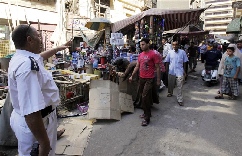Policemen disperse street sellers who had illegally occupied walking areas in Cairo