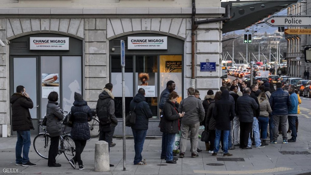 People queue to change their Swiss francs at a currency exchange office on January 15, 2015 in Geneva. In a shock announcement on January 15, Switzerland's central bank said it was ending a three-year bid to artificially hold down the value of the Swiss franc against the euro, in a move that immediately sent the safe haven currency soaring. Following the announcement, the Swiss franc strengthened 29 percent to 0.8517 against the euro. AFP PHOTO / FABRICE COFFRINI (Photo credit should read FABRICE COFFRINI/AFP/Getty Images)