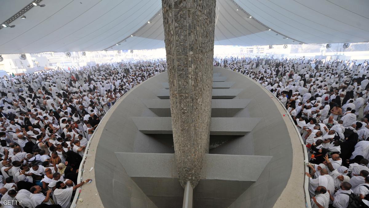 Muslim pilgrims throw pebbles at pillars during the "Jamarat" ritual, the stoning of Satan, in Mina near the holy city of Mecca, on October 15, 2013. Pilgrims pelt pillars symbolising the devil with pebbles to show their defiance on the third day of the hajj as Muslims worldwide mark the Eid al-Adha or the Feast of the Sacrifice, marking the end of the hajj pilgrimage to Mecca and commemorating Abraham's willingness to sacrifice his son Ismail on God's command in the holy city of Mecca. AFP PHOTO/FAYEZ NURELDINE (Photo credit should read FAYEZ NURELDINE/AFP/Getty Images)